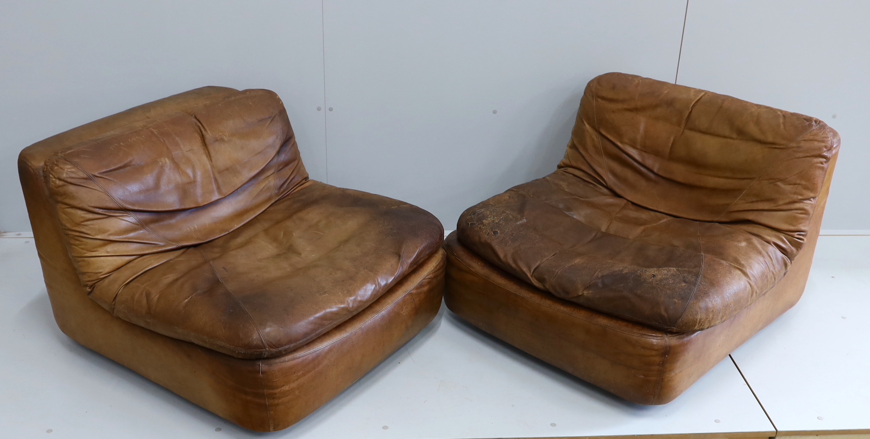 A pair of German Dreipunkt tan leather easy chairs, width 86cm, depth 96cm, height 60cm